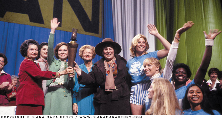 First Ladies Lady Bird Johnson, Rosalynn Carter, and Betty Ford, International Women’s Year presiding officer Bella Abzug, and Torch of Freedom relay runners at the opening ceremonies of the National Women’s Conference, Houston, November 1977